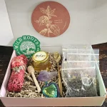 A beautiful Mystery Tea Gift Box containing a tea sampler, local honey, a tea strainer, a sage stick, and a crystal.